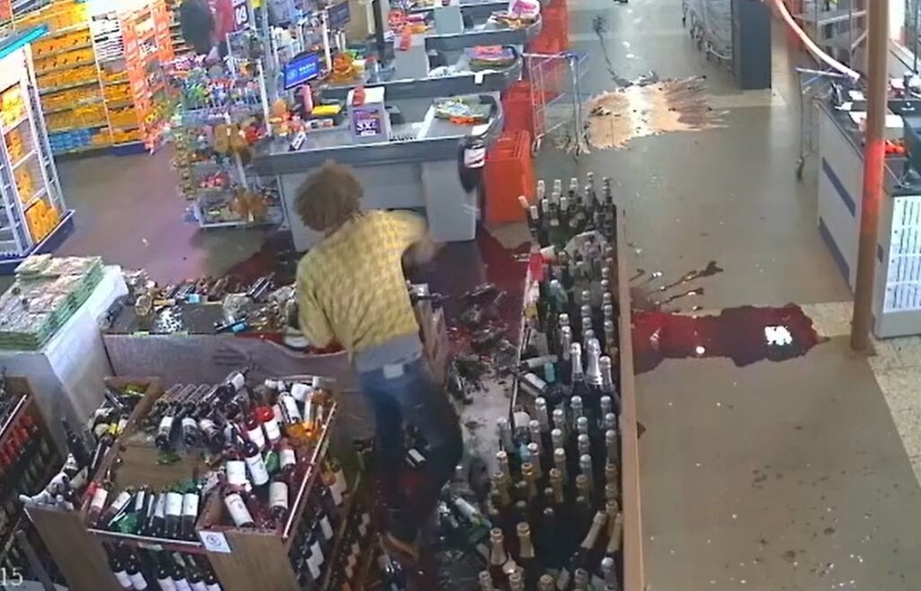 homem surta e quebra garrafas de vinho em mercado